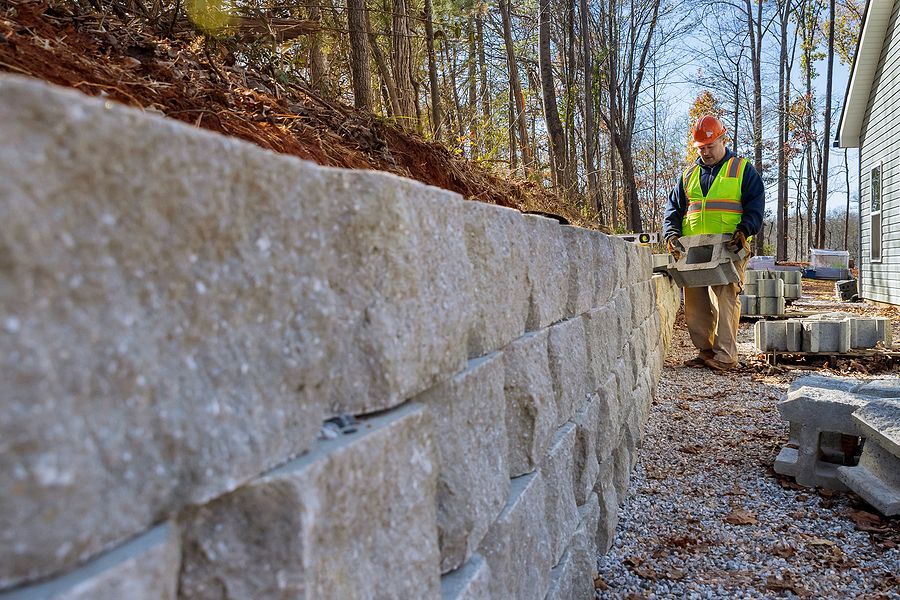 a man standing next to a stone wall