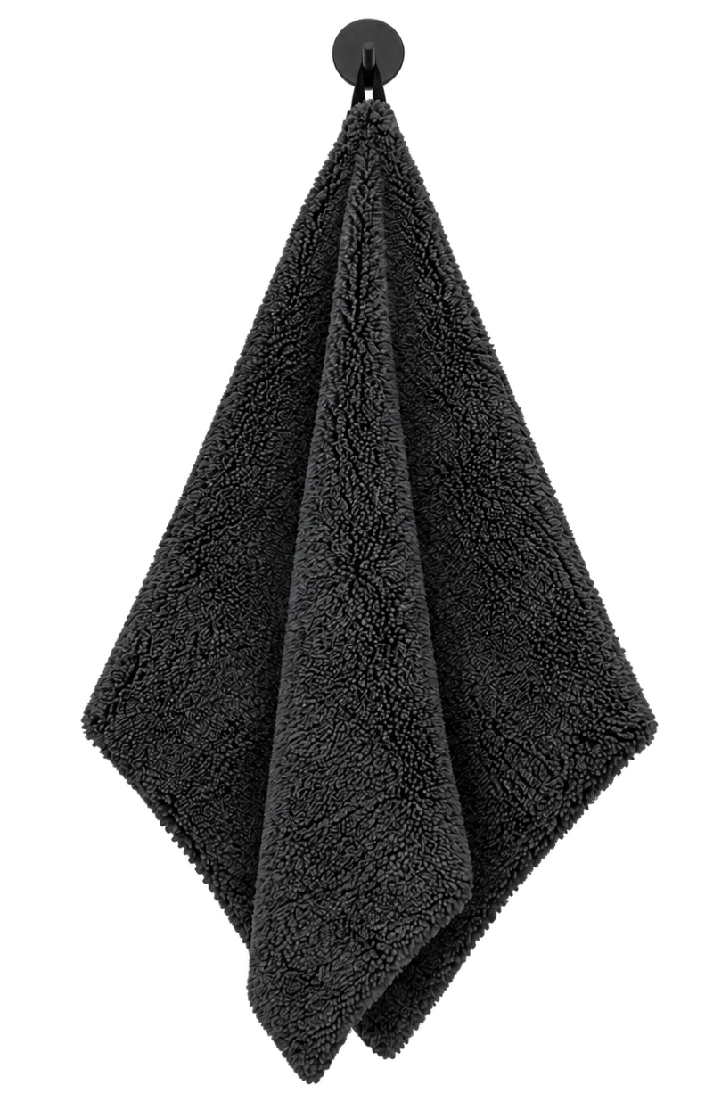 Dark gray textured towel hanging from a black wall hook