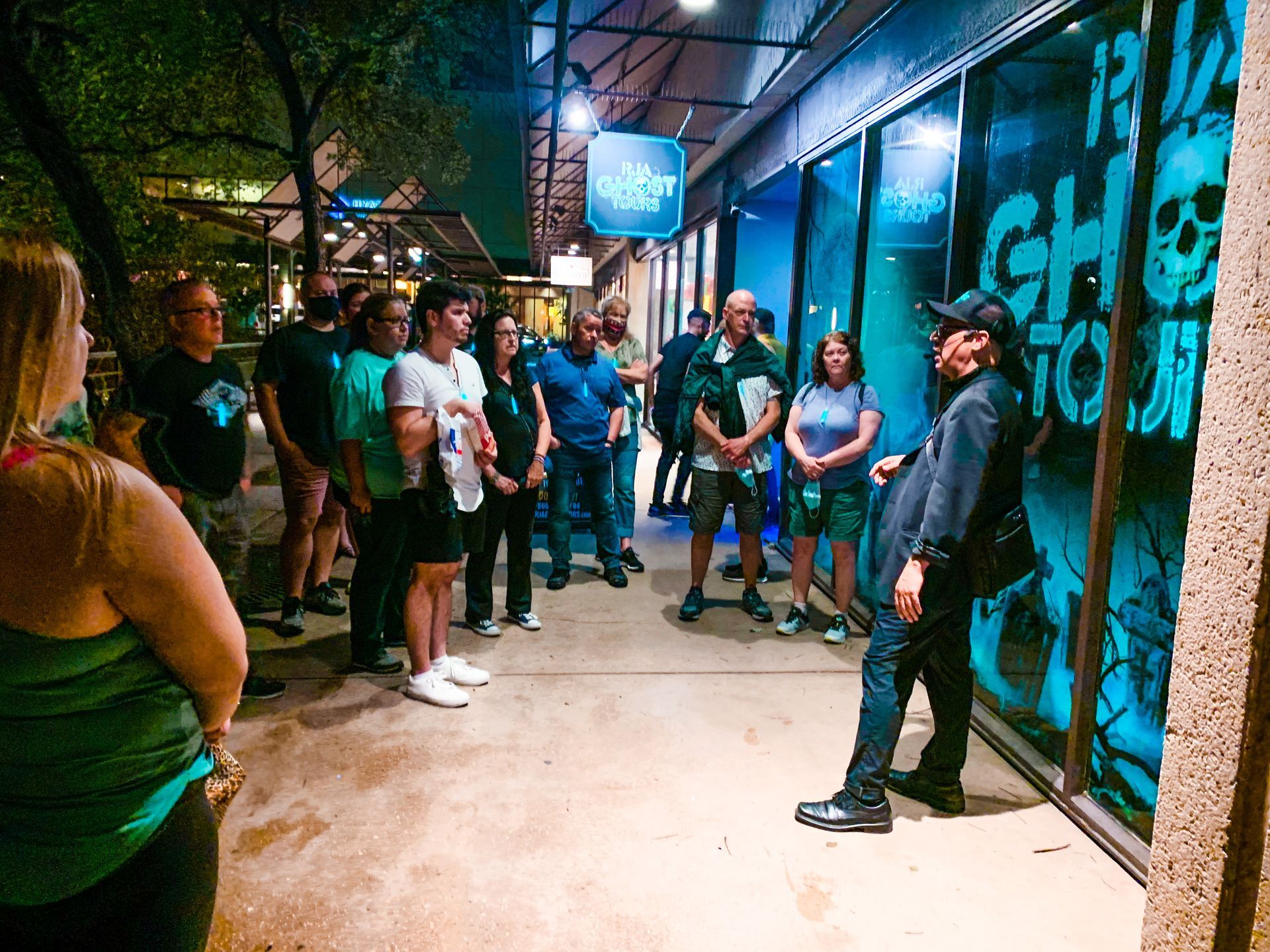 Ghost Tour guide standing in front of a RJA GHOST TOURS gift shop. 