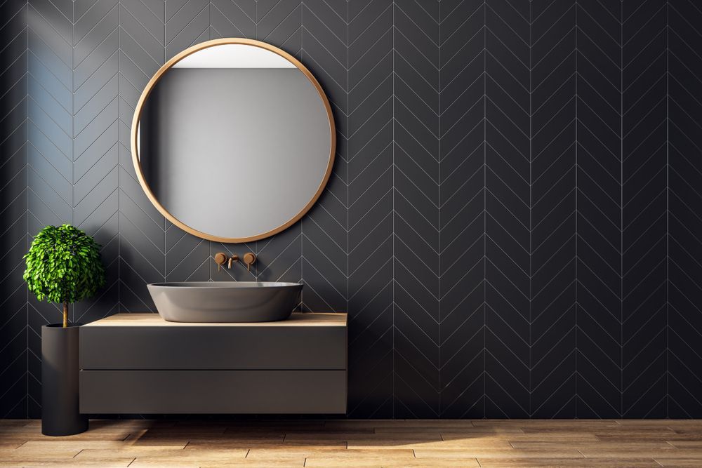 A Bathroom With A Sink, Mirror And Black Tiles — Hutchisons Tile Centre In Murwillumbah, NSW