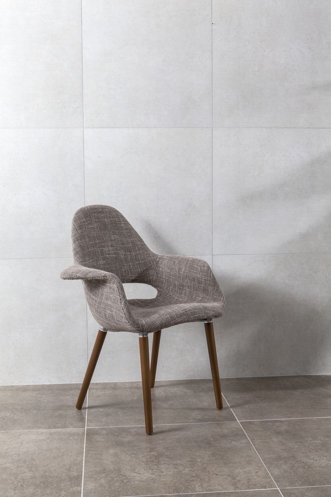 A Chair Is Sitting On A Tiled Floor In Front Of A White Wall — Hutchisons Tile Centre In Kingscliff, NSW