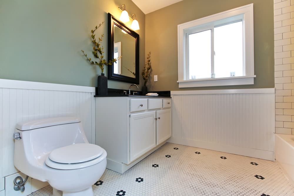 A Bathroom With A Toilet, Sink, Mirror And Window — Hutchisons Tile Centre In Murwillumbah, NSW