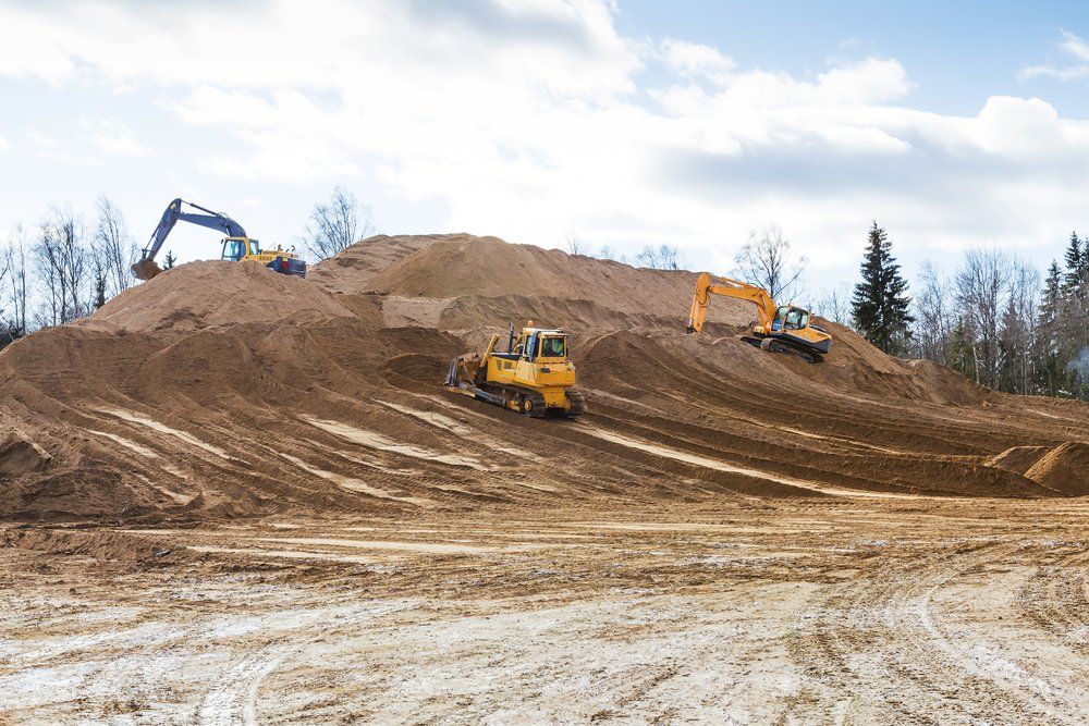 Chantier de construction avec des bulldozers et des excavatrices déplaçant de la terre.
