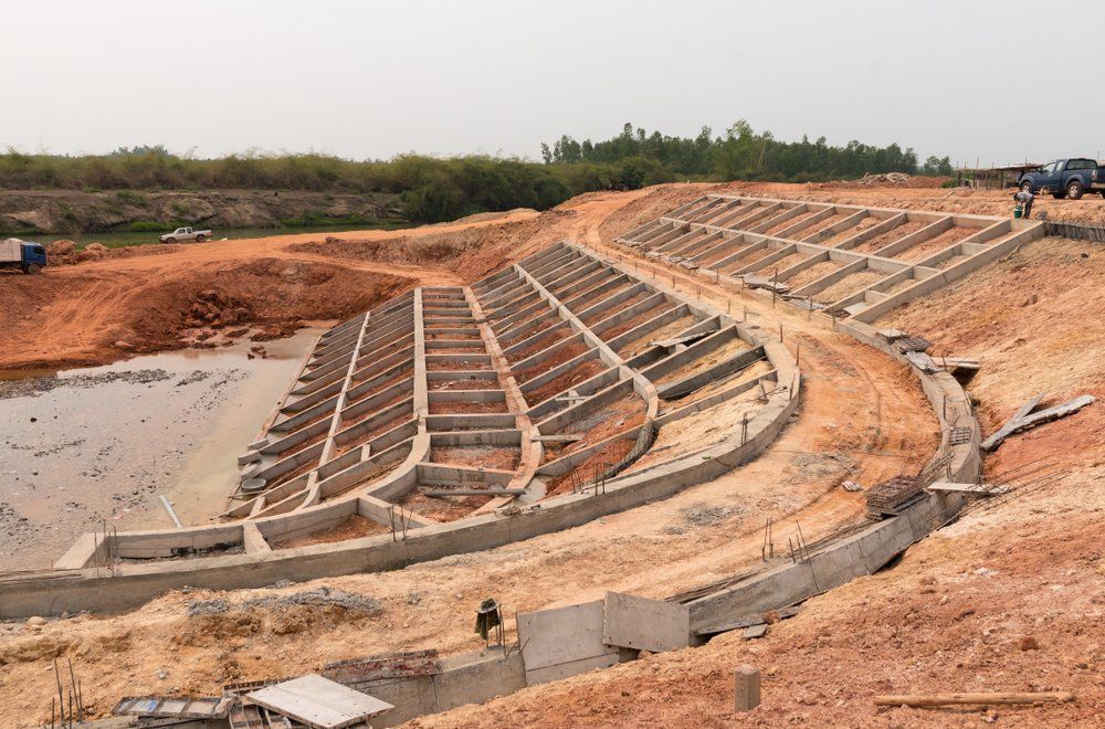 Chantier : structures en béton étagées ressemblant à des gradins de stade, installées dans une excavation.