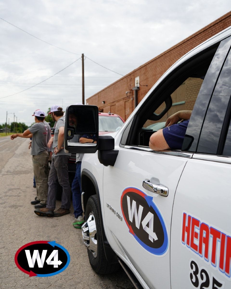 White work truck with W4 logo parked beside men in hard hats near a brick industrial building.