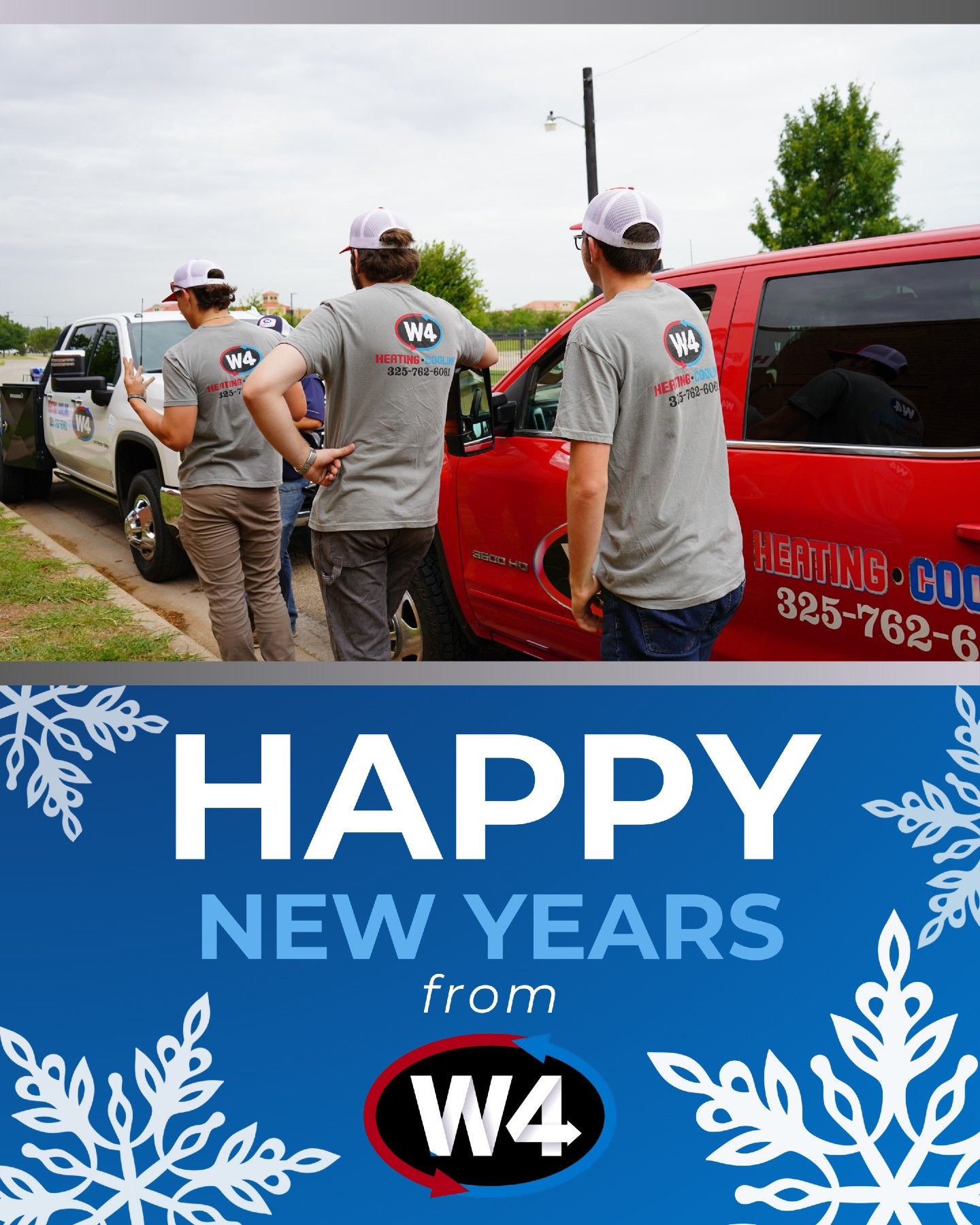 Workers by red trucks under a “Happy New Year” W4 holiday banner