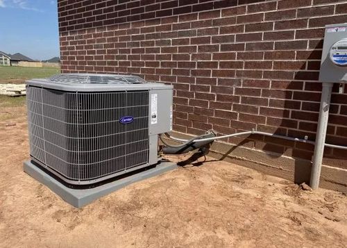 Exterior wall with mounted mini-split AC unit, electrical box, and window unit along a narrow side yard.