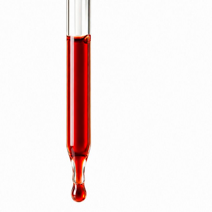 Red liquid in a laboratory dropper against a white background
