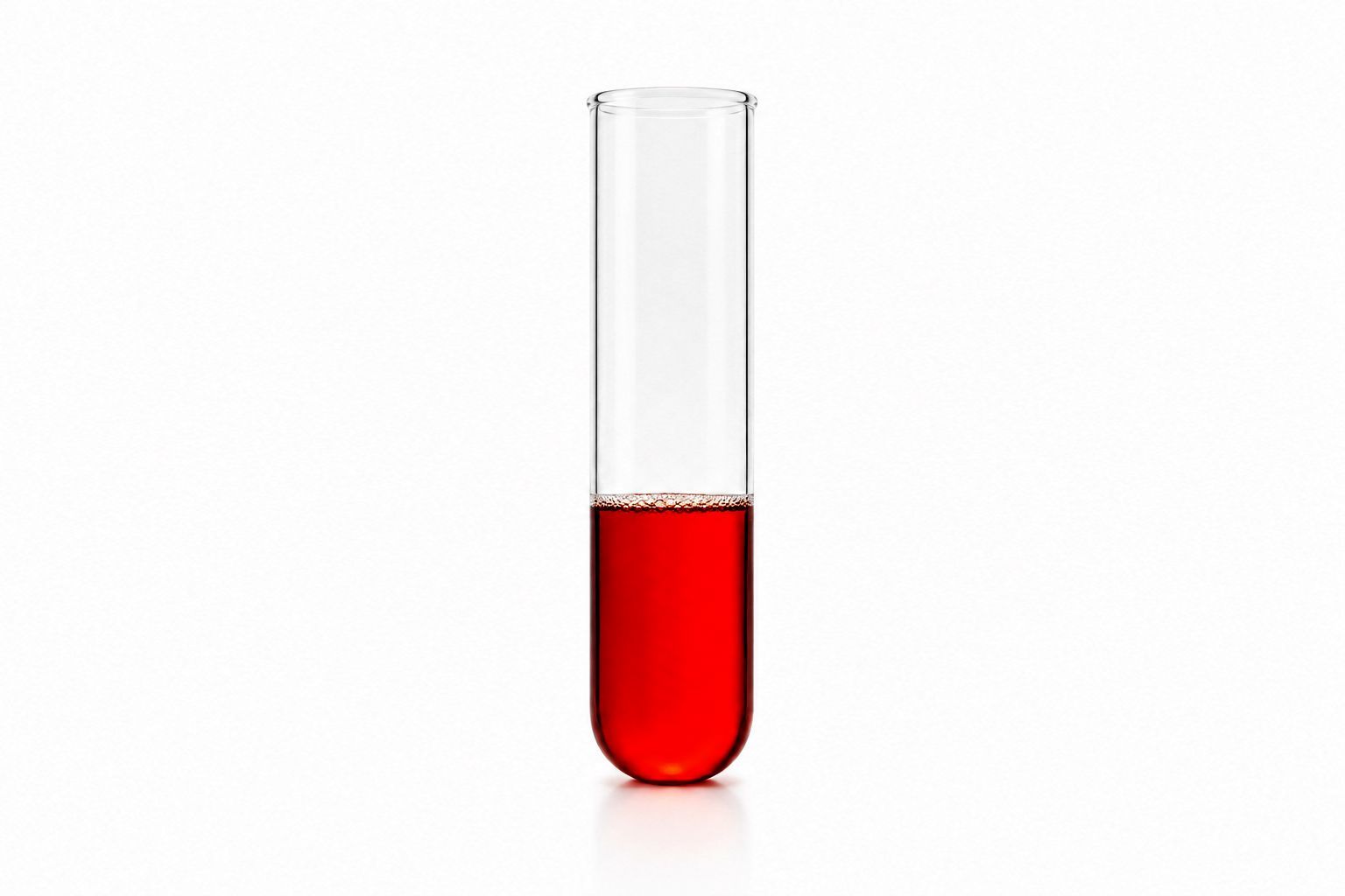 A clear glass test tube partially filled with red liquid on a white background