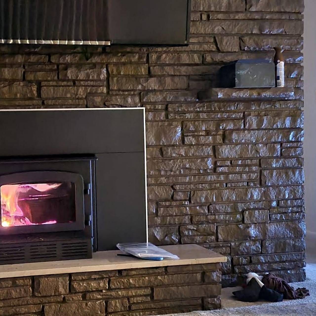 A fireplace in a living room with a brick wall