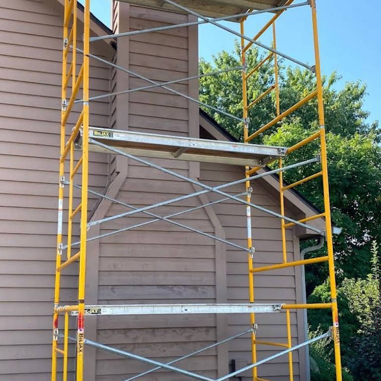 A yellow scaffolding is sitting in front of a house