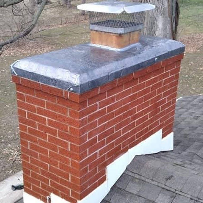 A brick chimney with a metal cap on top of it