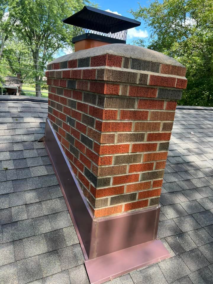 A brick chimney is sitting on top of a roof.