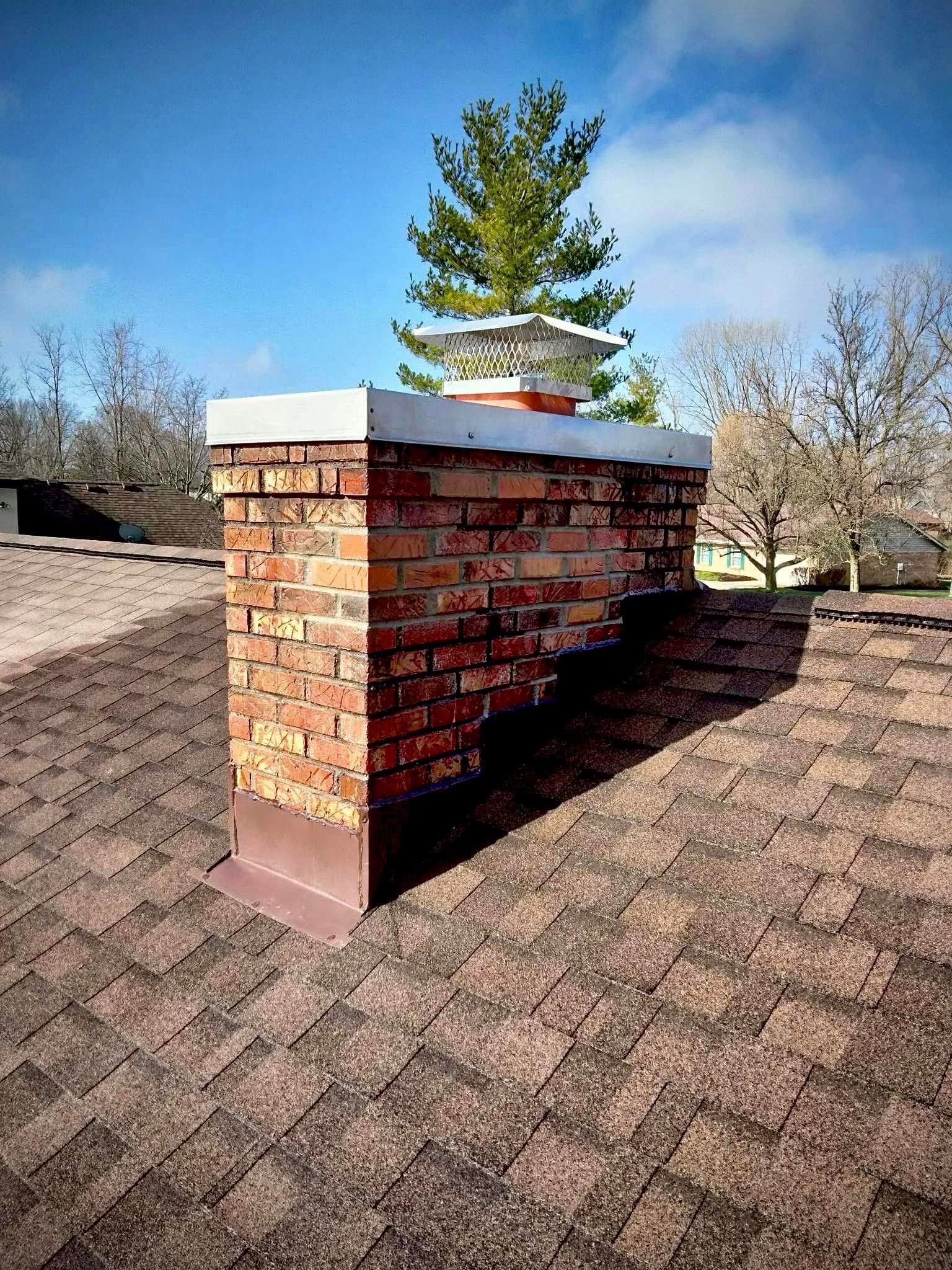 A brick chimney is sitting on top of a roof.