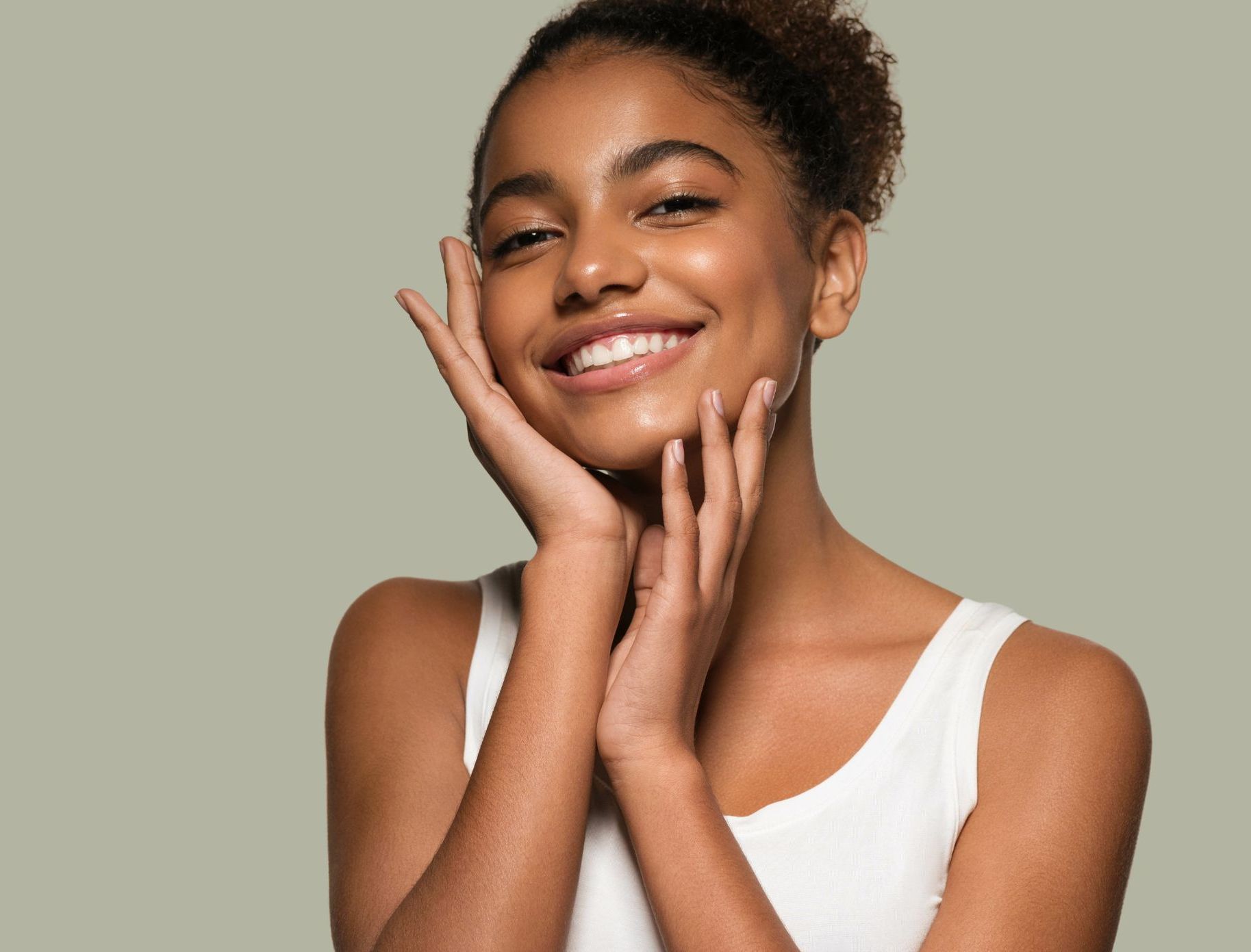 pretty young black woman with fresh skin touches face