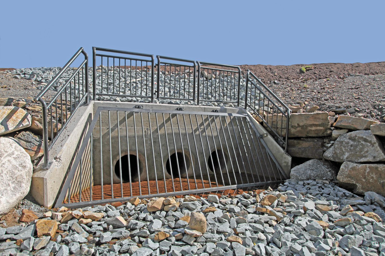 A bridge over a rocky area with a metal railing