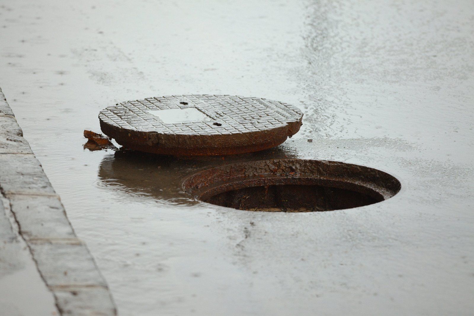 A manhole cover is sitting on top of a hole in the ground.