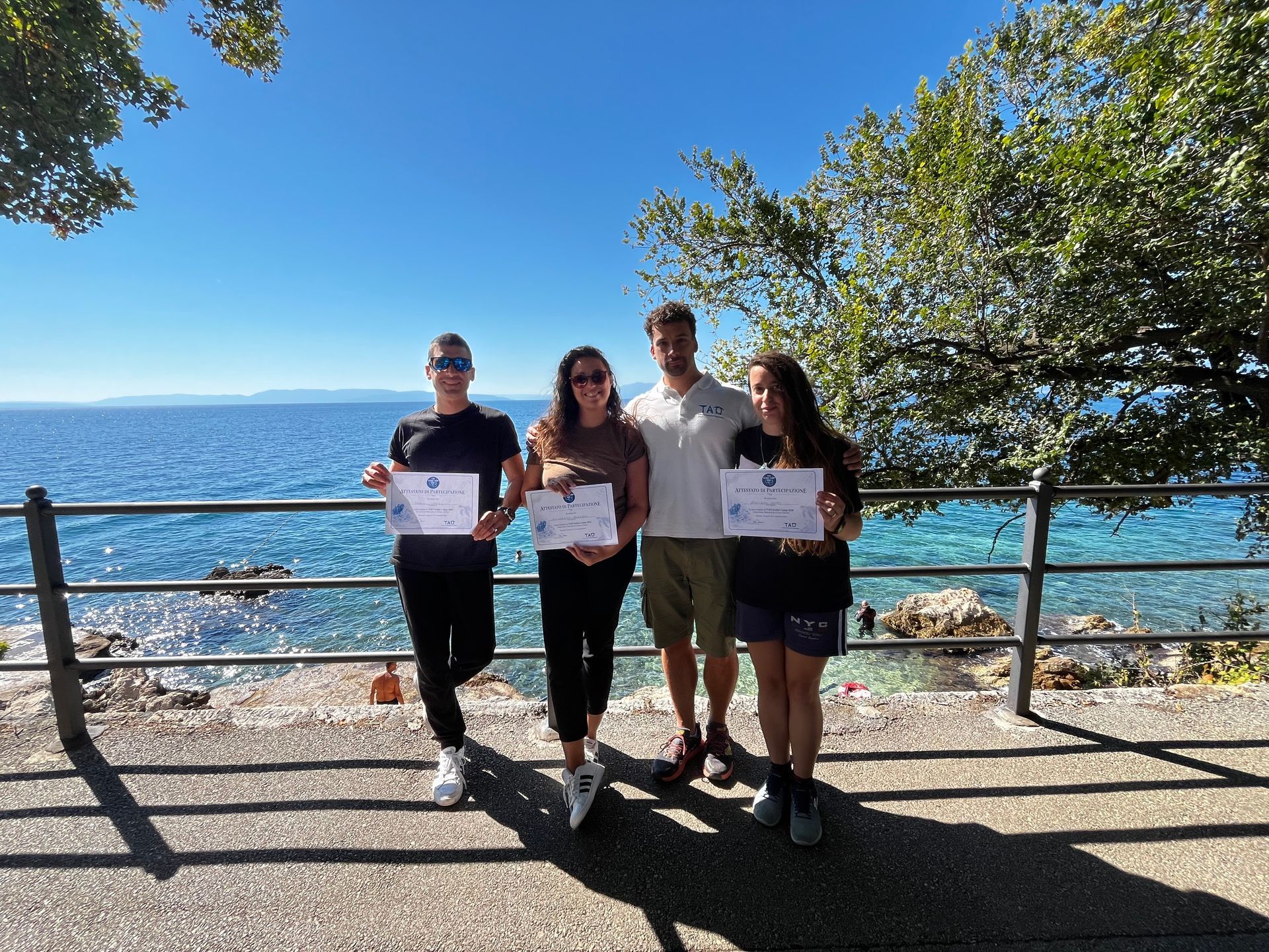Quattro persone con un certificato di partecipazione del camp di subacquea scientifica