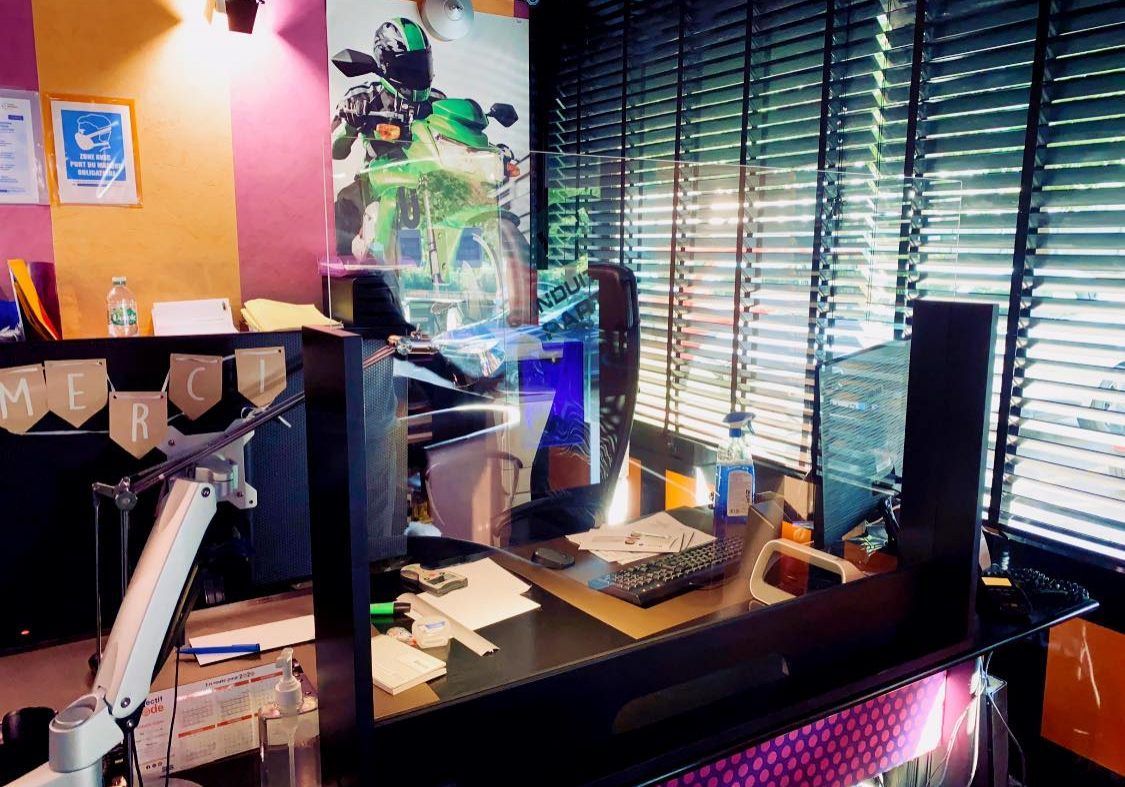Une pièce avec un bureau d'ordinateur et une fenêtre avec des stores