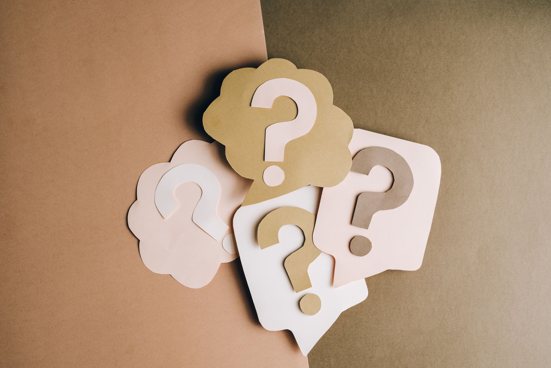 Speech bubbles with question marks on brown and tan background.
