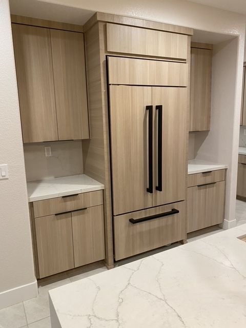A kitchen with wooden cabinets and a refrigerator.