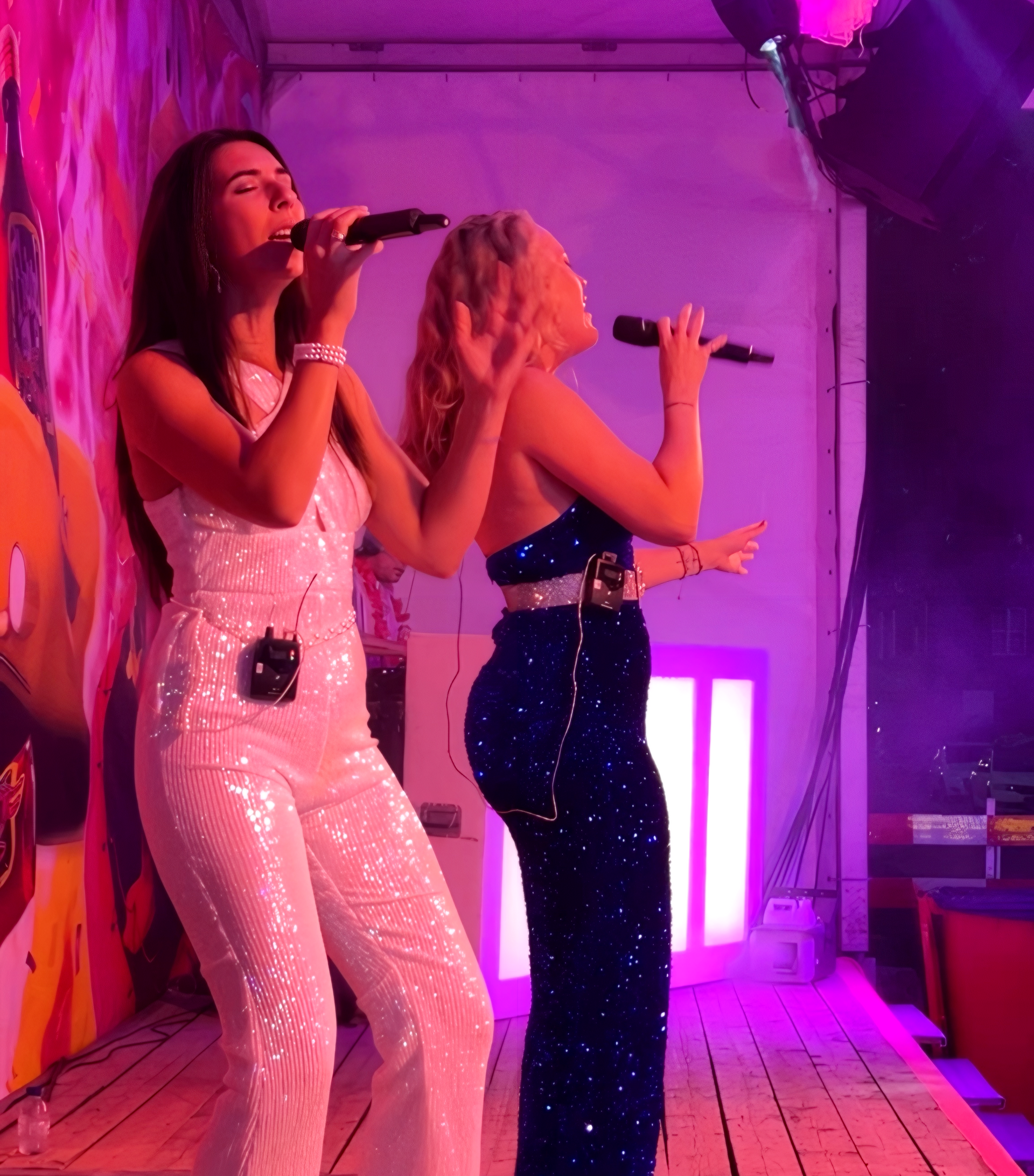 Twee zangeressen treden op op een roze verlicht podium. Tribtueshow ABBA.