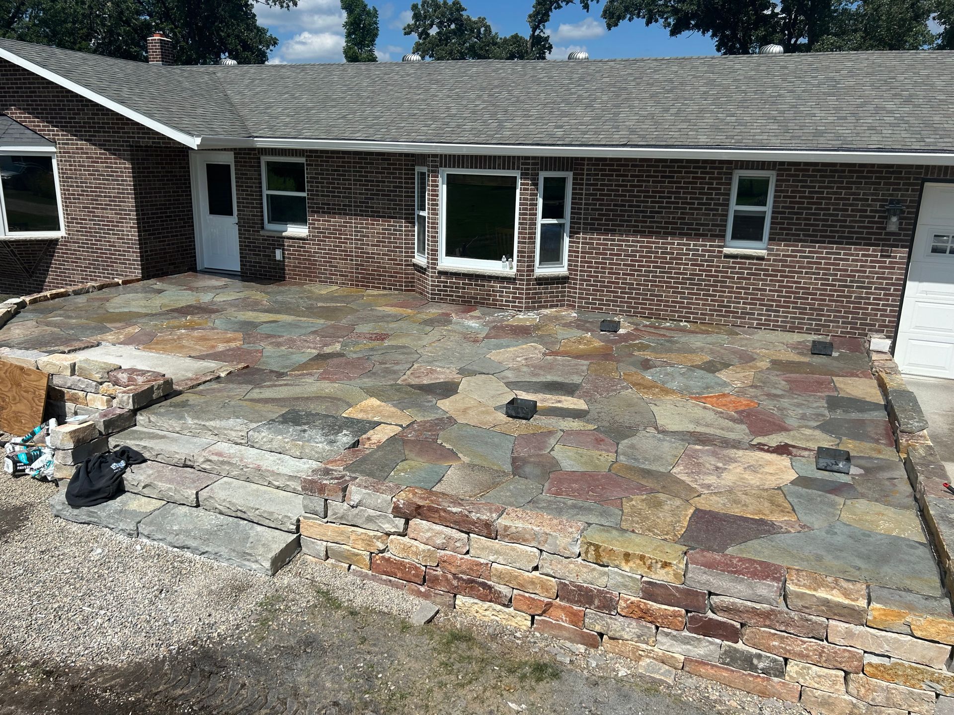 A brick house with a stone patio in front of it