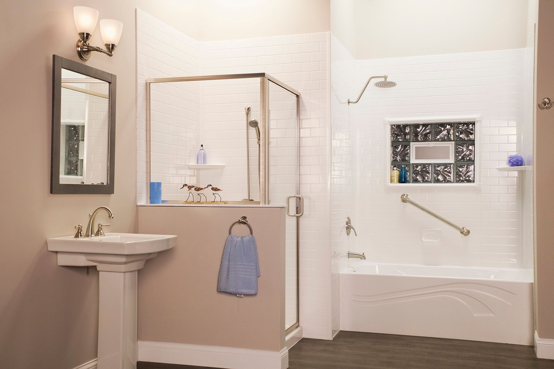 Accessible bathroom with sink, walk-in shower, grab bars, and towel rack in beige and white tones