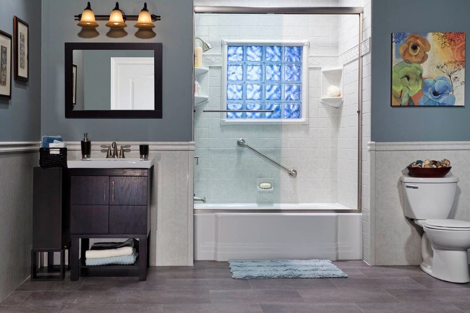 Modern bathroom with dark vanity, glass shower, toilet, and blue-gray walls