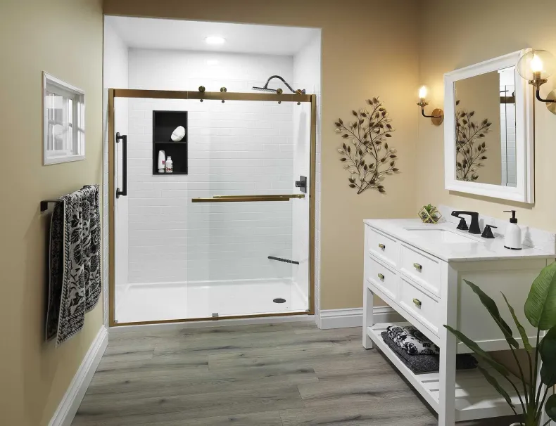 Bright bathroom with glass shower, white vanity, wood floor, and beige walls.