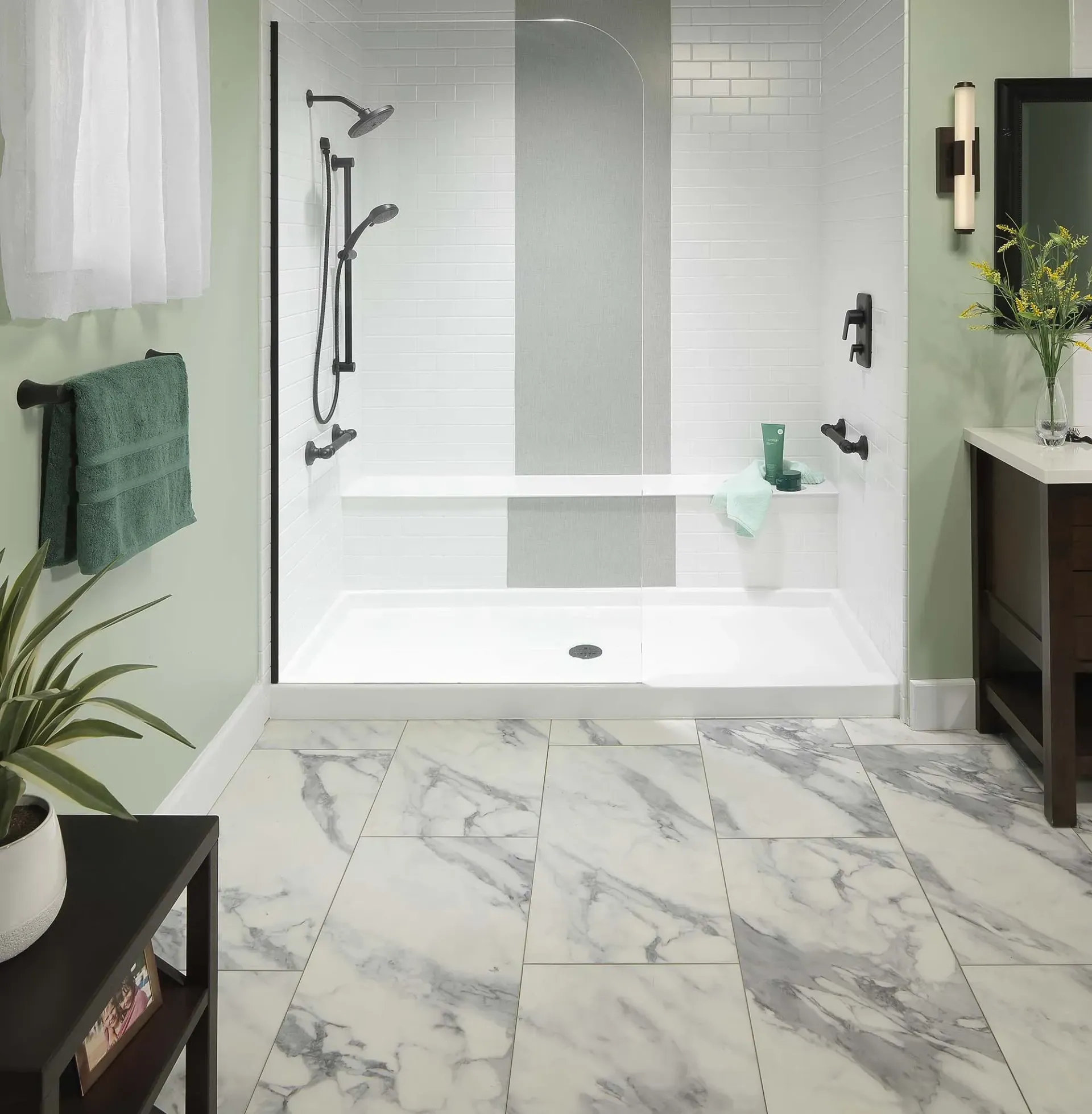 Modern bathroom with a glass walk-in shower, white tub, and marble-look floor tiles