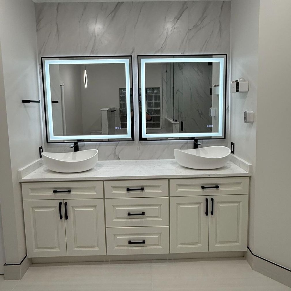 White double vanity with two vessel sinks and lit mirrors in a modern bathroom