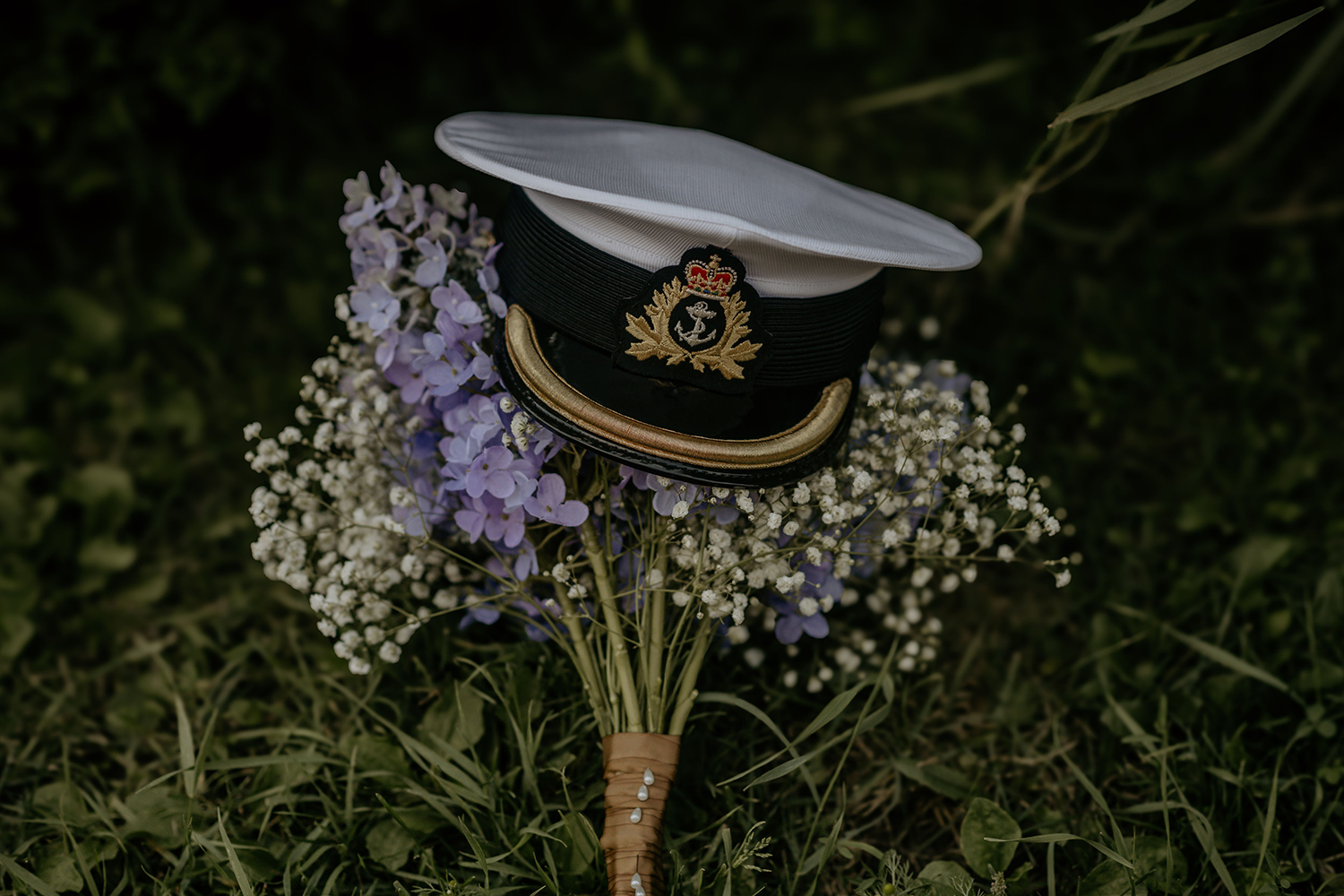 A hat is sitting on top of a bouquet of flowers.