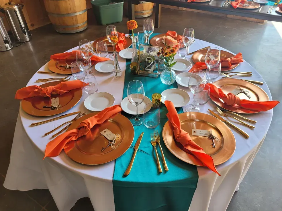 A table set for a wedding reception with plates , utensils and napkins.