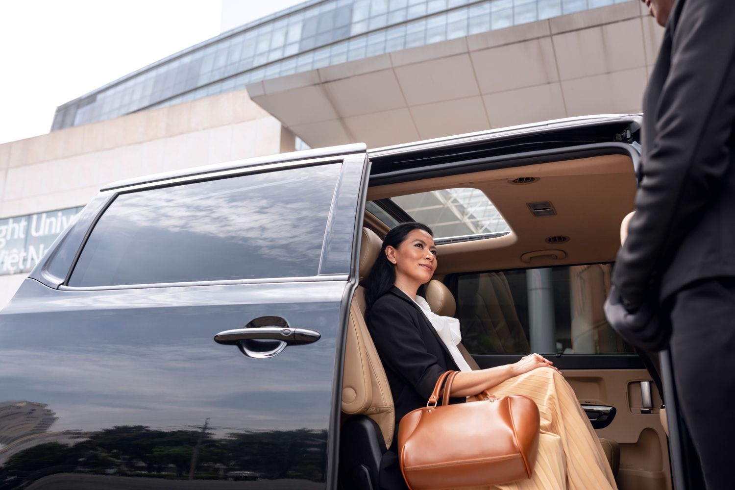 A woman is sitting in the back seat of a car.