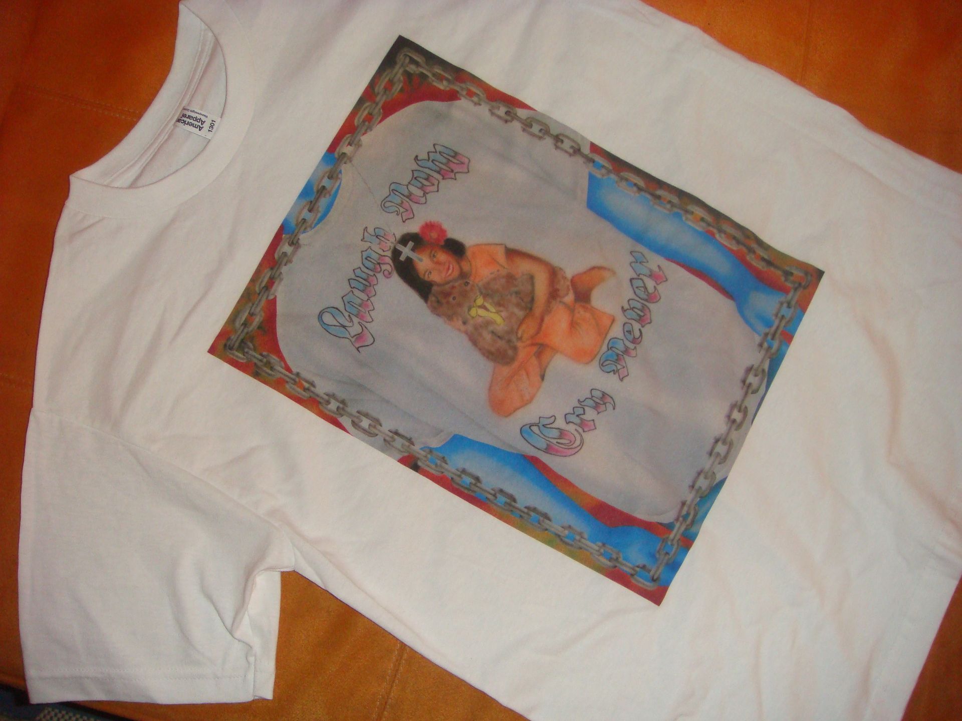 A woman is covering her face with a white shirt with a picture of a woman on it