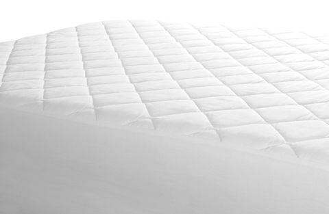 Un primer plano de un protector de colchón blanco en una cama.