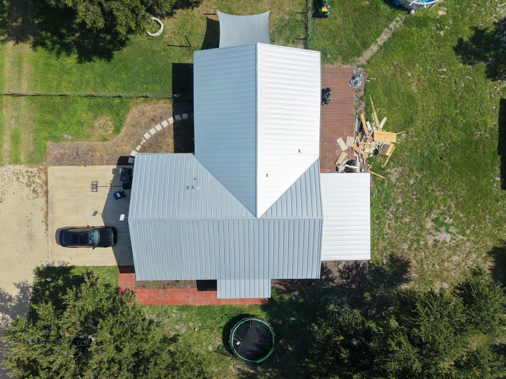 Silver corrugated metal roof against a blue sky with scattered clouds