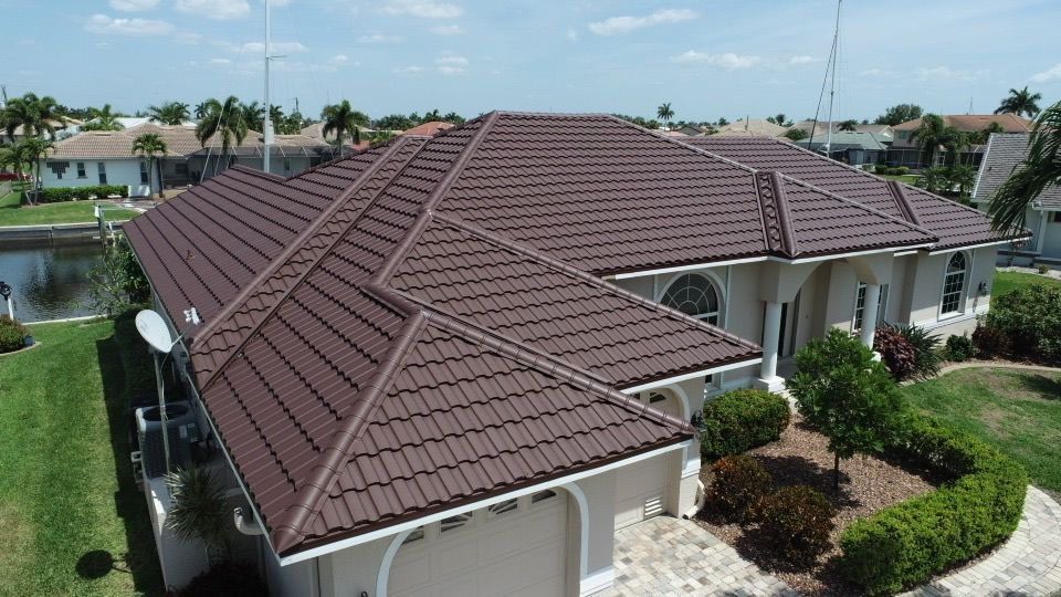 Aerial view of a beige tiled roof with skylights and a dark-blue roof section.