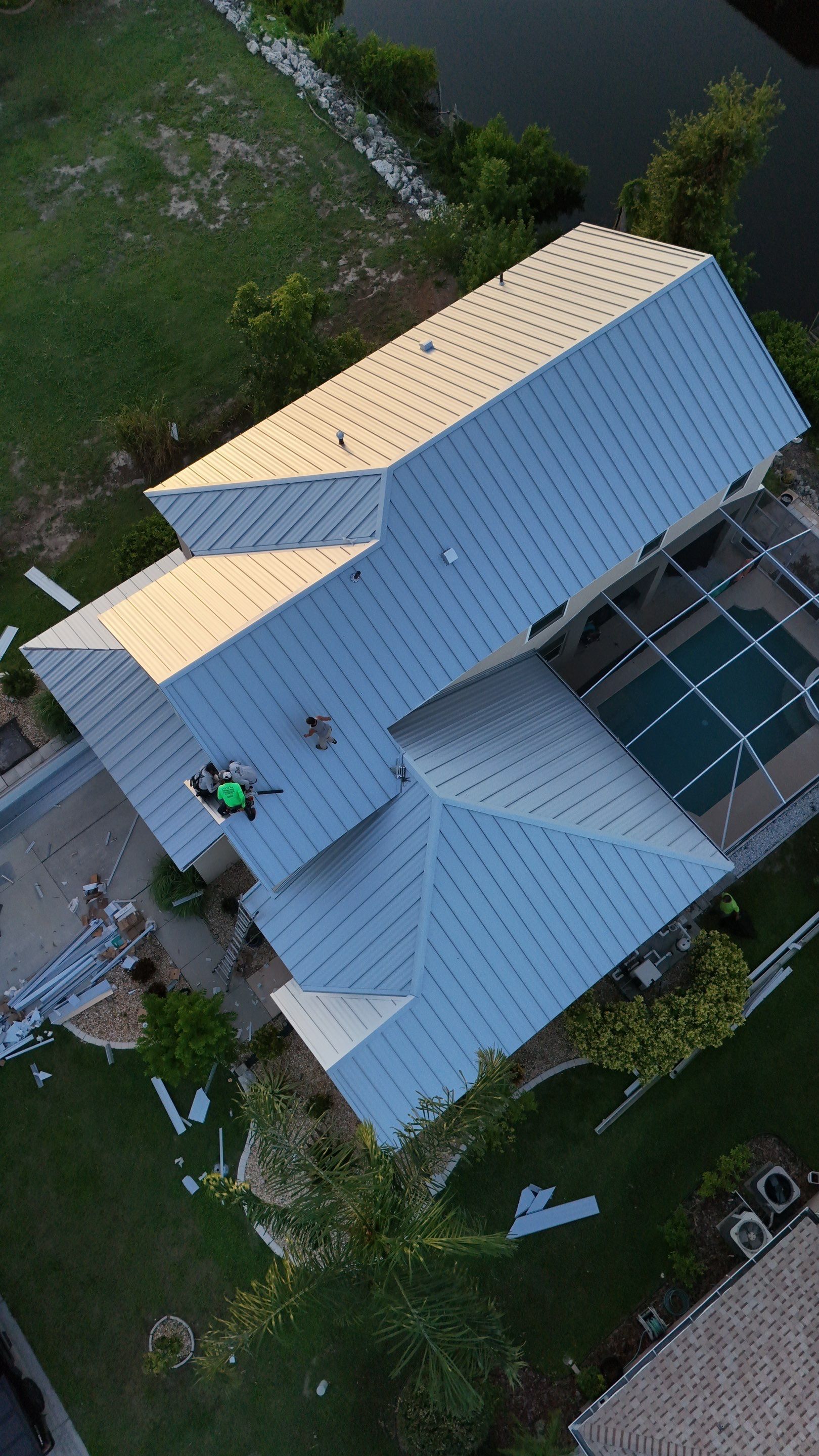Attic vent beneath a shingled roof with a white support beam and triangular opening