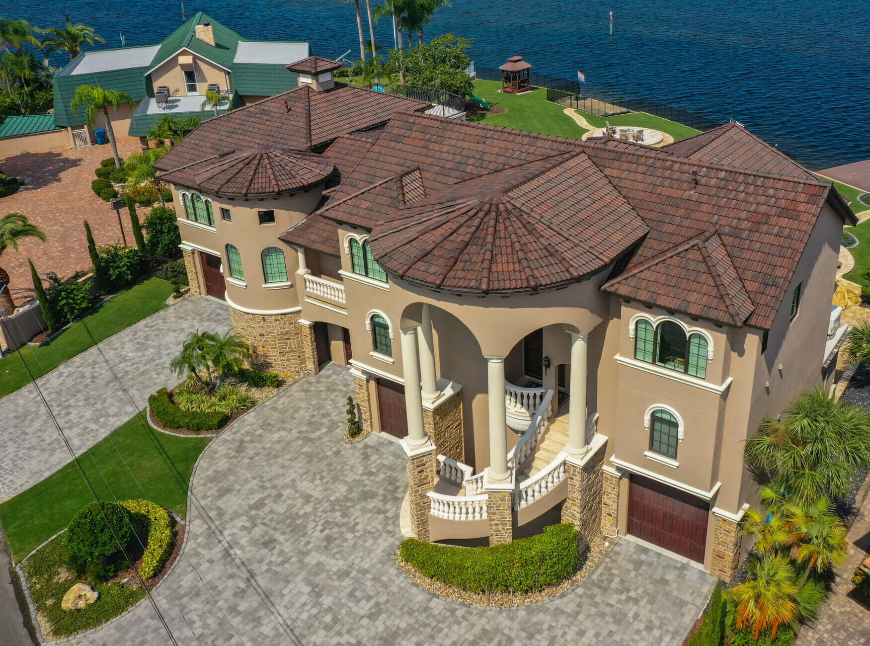 Rooftop dormer with white trim and brown shingles on a tiled roof
