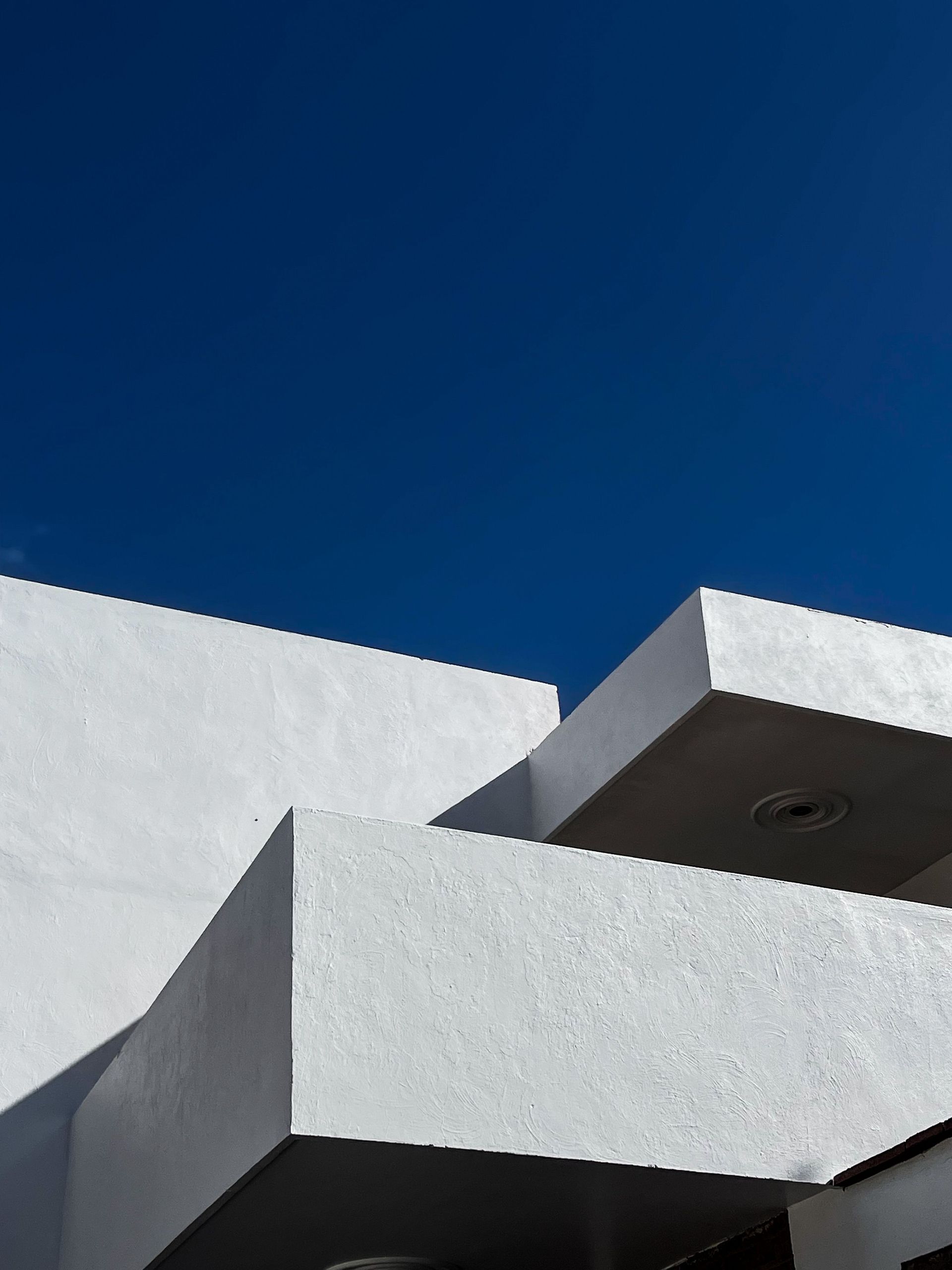 White building roof against a clear deep blue sky
