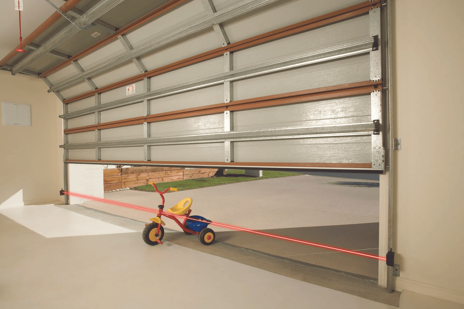 A tricycle is parked in a garage with the door open.