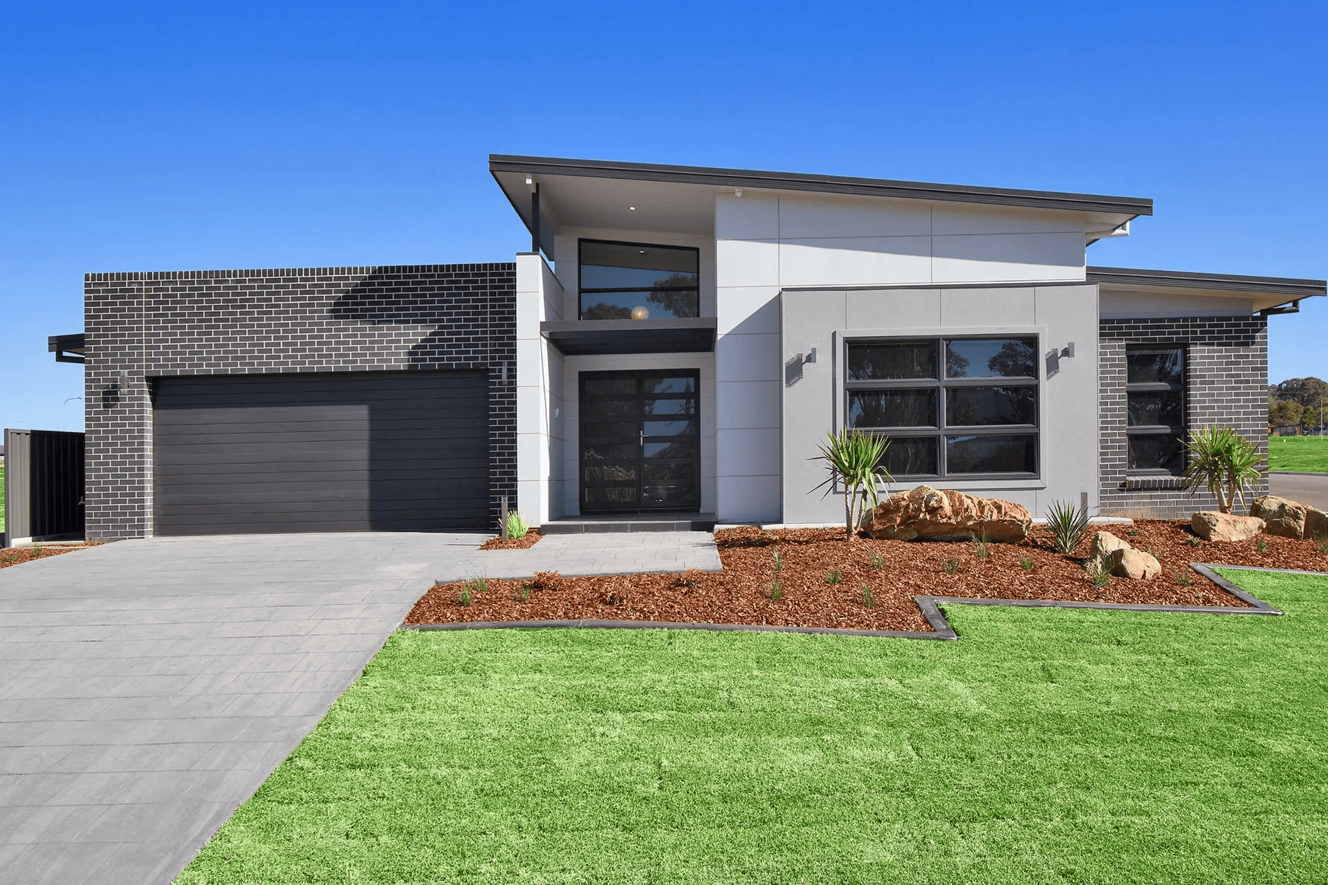 A modern house with a lush green lawn in front of it