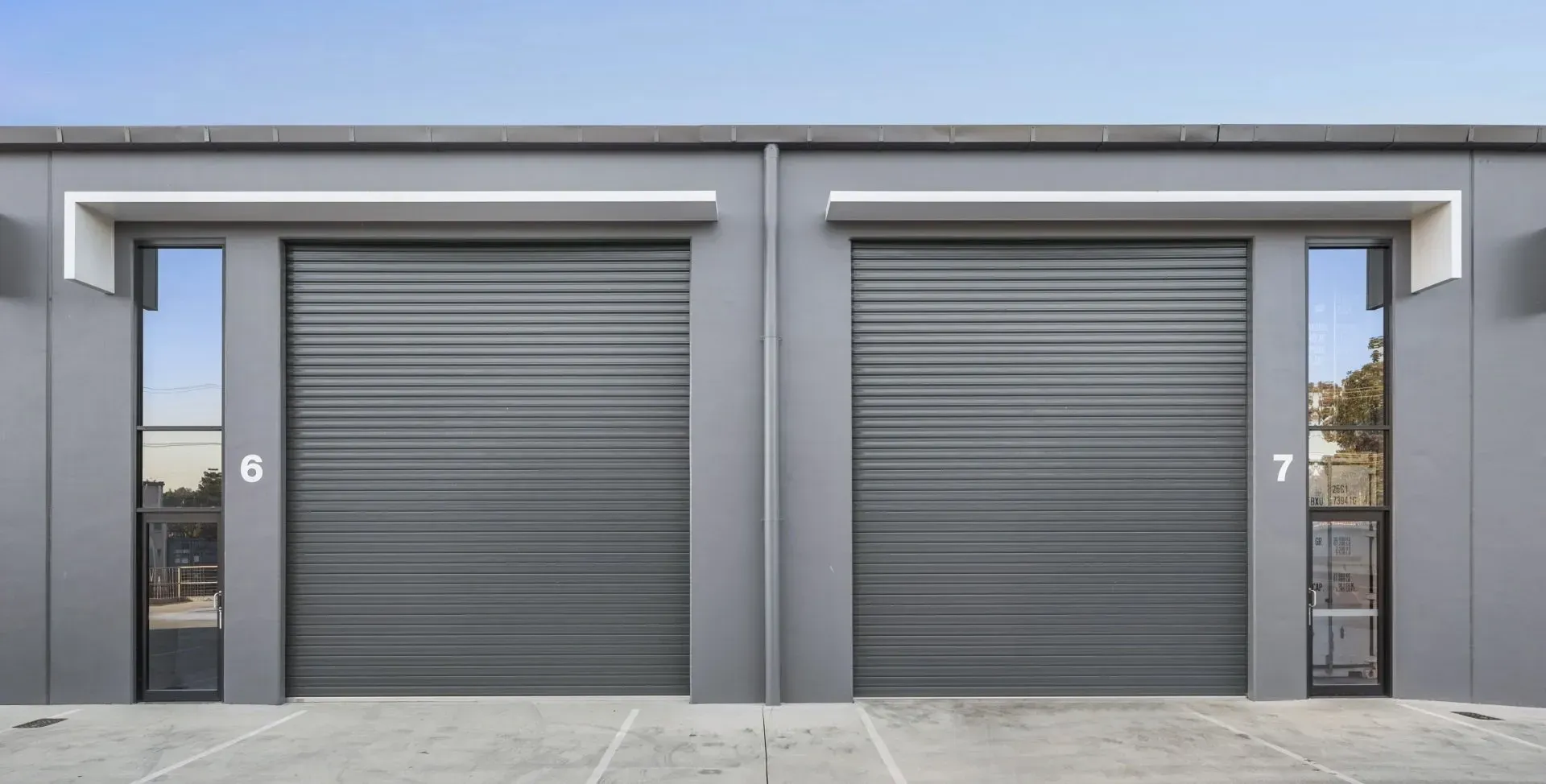 There are two garage doors on the side of a building.