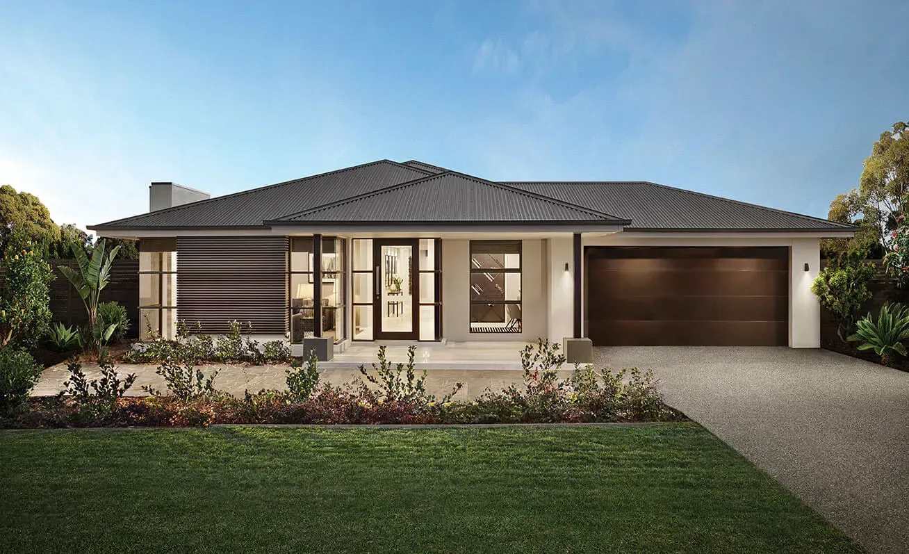 A modern house with a large garage and a lush green yard.