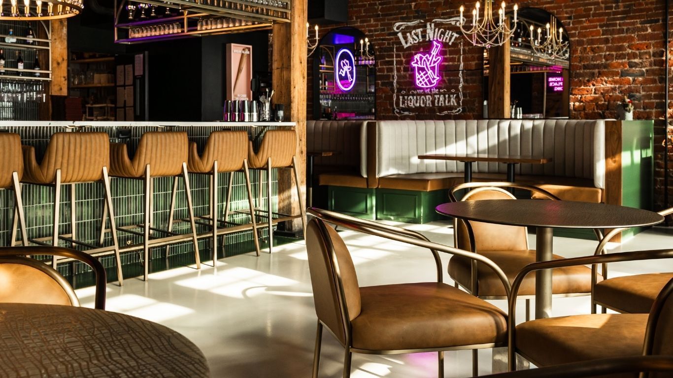 A thoughtfully designed commercial restaurant and entertainment venue with curved booths and neon signs