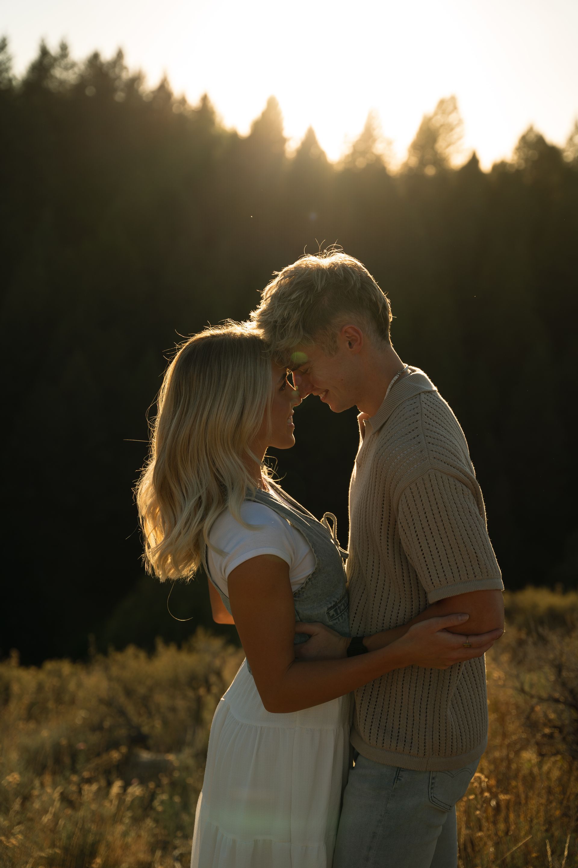 A man and a woman are standing next to each other in a field.