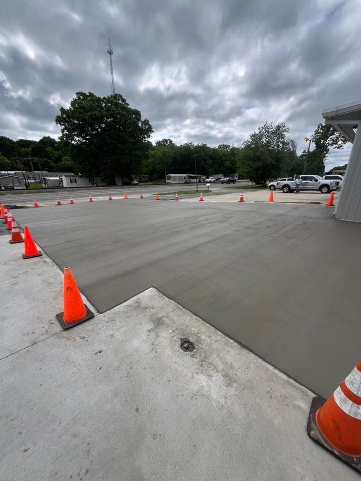 Empty parking lot with orange traffic cones under a cloudy sky