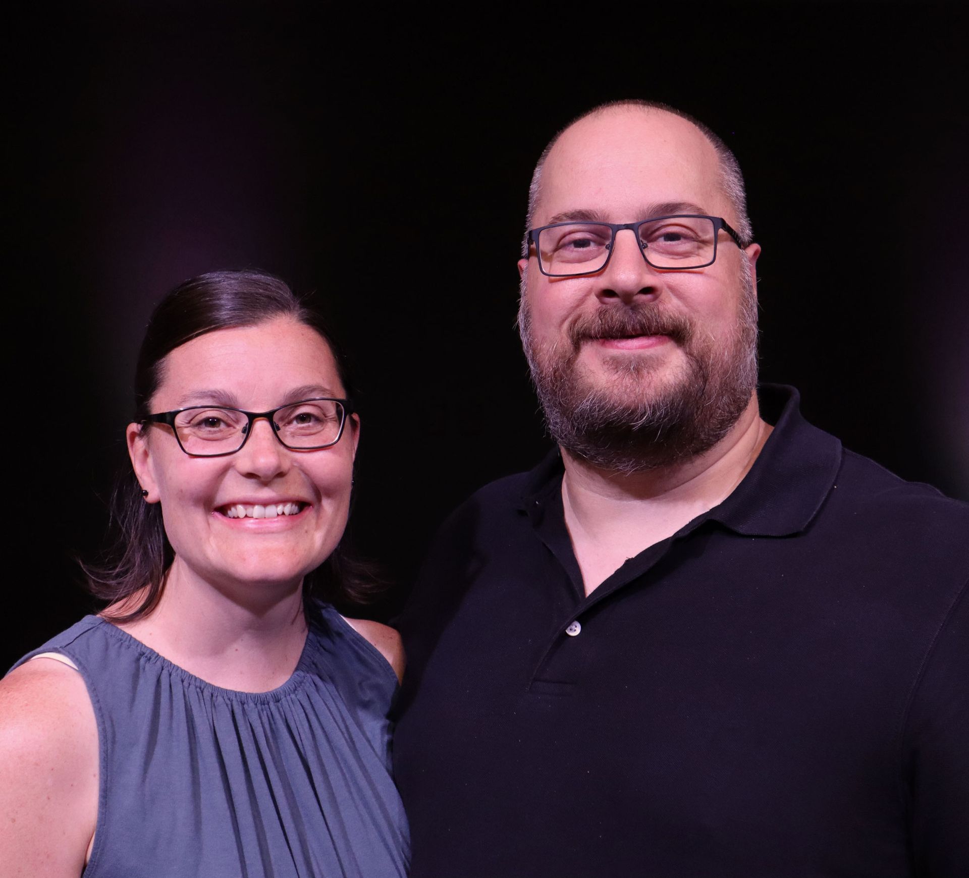 A man and a woman wearing glasses are posing for a picture.